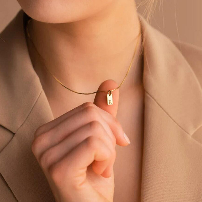 Collier en acier inoxydable avec pendentif étiquette simple à 26 lettres.